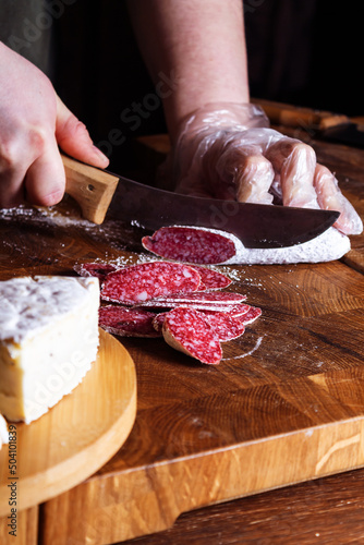 Close-up of sliced salami on wooden board.