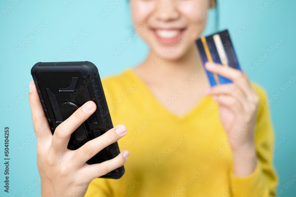 Young woman takes a photo of herself using a smartphone and credit card to pay online. Young woman takes a photo of herself using a smartphone and credit card to pay online.