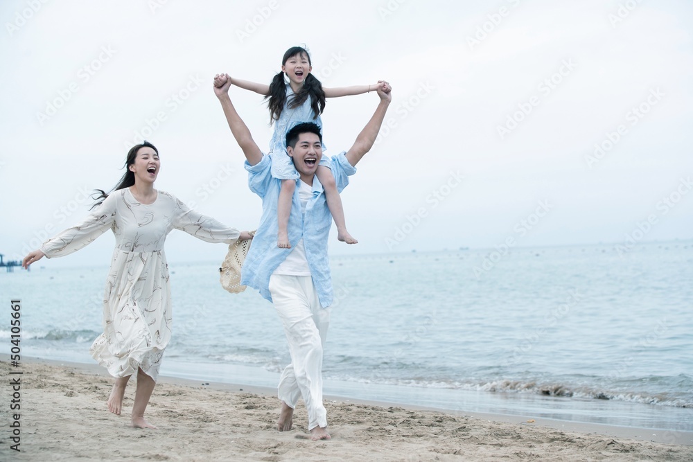 Family of three playing on the beach Family of three playing on the beach