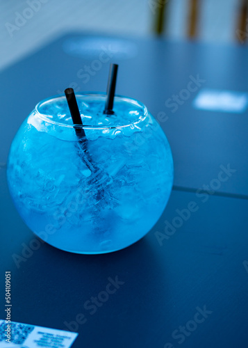 blue cocktail in the shape of a fishbowl to share. new cocktail in crystal glass
