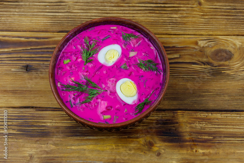 Cold beetroot soup on a wooden table. Top view