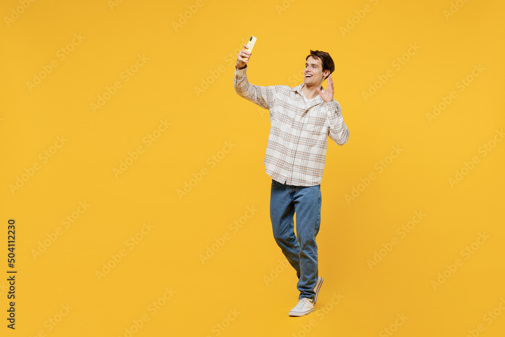 Full body young smiling happy cheerful caucasian man 20s wearing white casual shirt doing selfie shot on mobile cell phone post photo on social network show v-sign isolated on plain yellow background Full body young smiling happy cheerful caucasian man 20s wearing white casual shirt doing selfie shot on mobile cell phone post photo on social network show v-sign isolated on plain yellow background