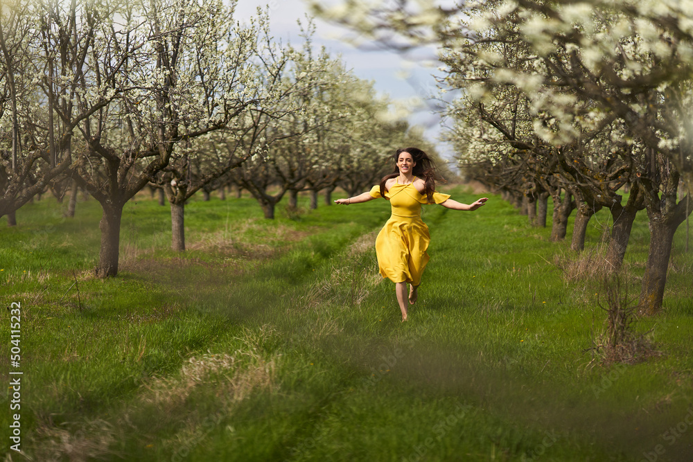 Happy woman in the blooming orchard