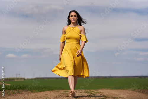 Young woman on a dirt road, barefoot