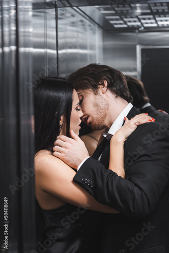 Sexy elegant couple kissing in elevator.