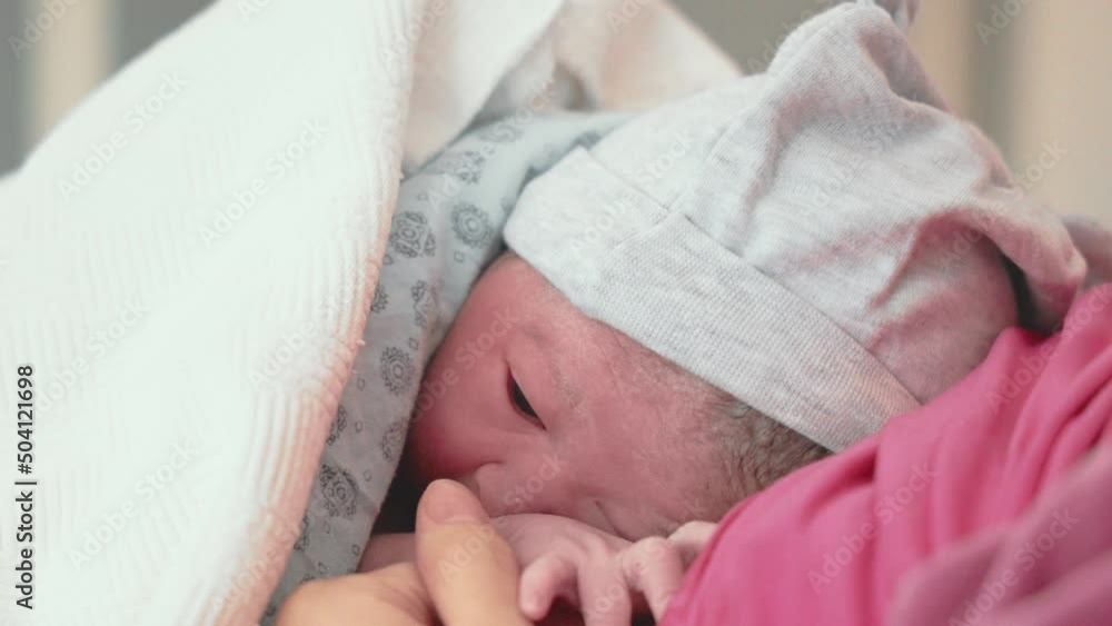 Newly born baby lies on his mother after delivery Newly born baby lies on his mother after delivery