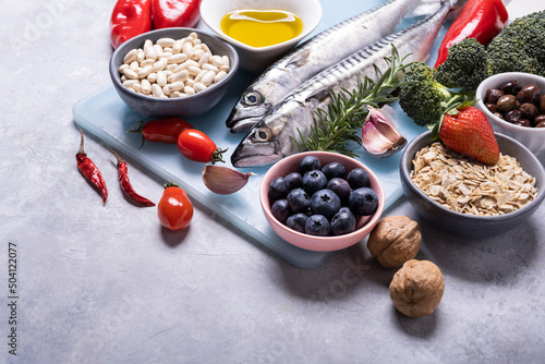 on the textured background, variety of Mediterranean healthy foods based on legumes, fish, vegetables, fruits and grains