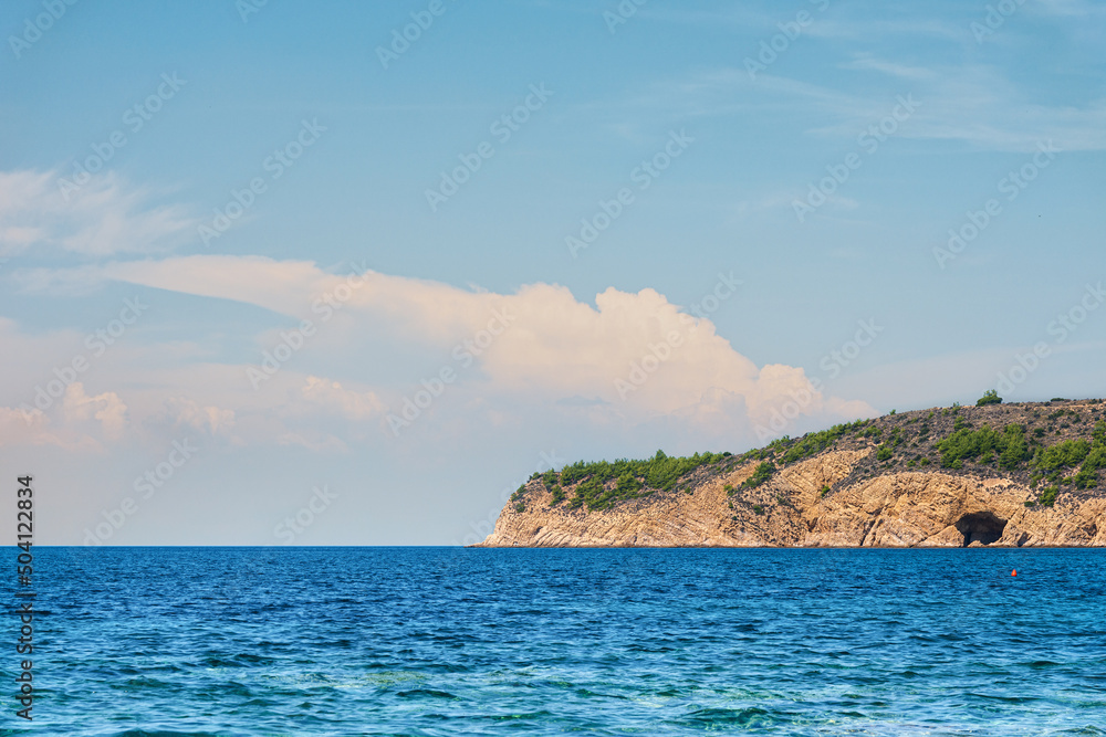 Beautiful blue sea with part of mountain coastline and cloudy sky