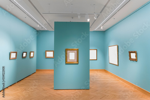 A lot of small rustic and old frames for pictures hanging on a wall of a exebition