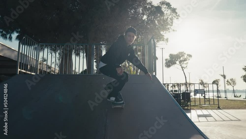 Skater boy practicing at skate park. Young man doing skateboard tricks at skateboard park