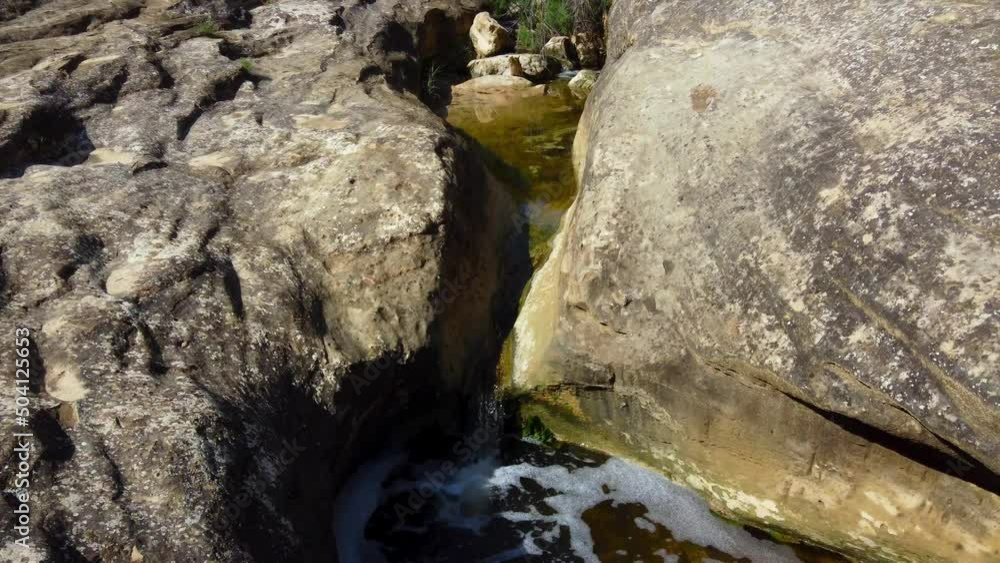 Water erodes a course through the granite rocks at Giant's Cauldron near Alicante, Spain - following the source of the stream Water erodes a course through the granite rocks at Giant's Cauldron near Alicante, Spain - following the source of the stream
