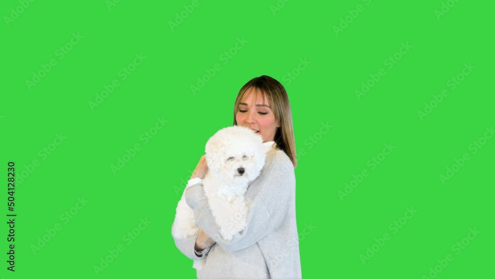 Charming girl standing with bichon frise in her hands on a Green Screen, Chroma Key. Charming girl standing with bichon frise in her hands on a Green Screen, Chroma Key.
