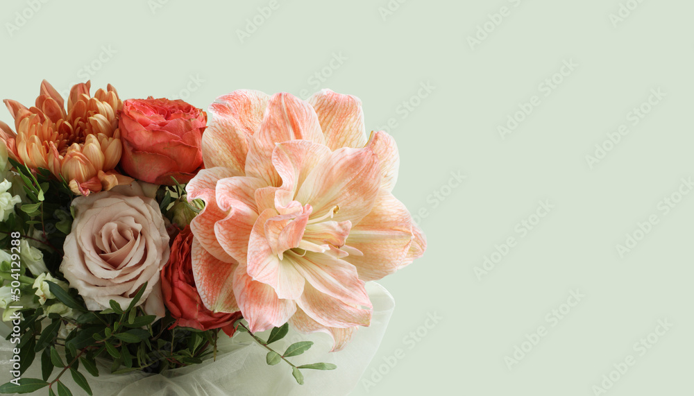 A bouquet of peach daylilies, orange and pink roses and beige chrysanthemums on light green background. Closeup. Long banner