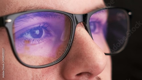 Wallpaper Mural Focused office worker wears black-rimmed glasses for reducing eye strain. Young man in spectacles looks at screen working on computer closeup Torontodigital.ca