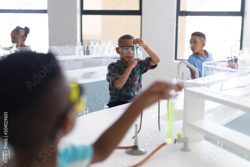 African american elementary schoolboys performing scientific experiment during chemistry class