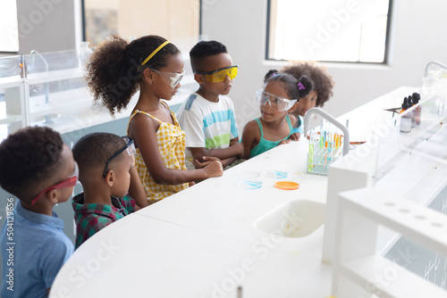 African american elementary school students performing chemical experiment during chemistry class
