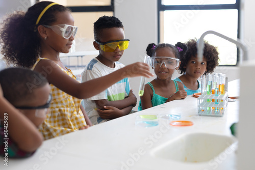African american elementary school students performing scientific experiment during chemistry class