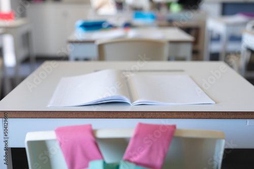 Close-up of open book on desk in classroom