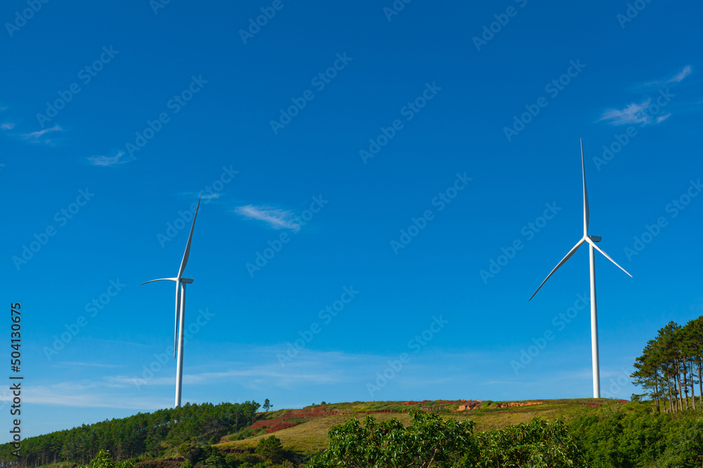 Renewable energy wind turbines windmill isolated on the beautiful blue sky and on the tea fields in Da Lat city, Lam Dong, Viet Nam Renewable energy wind turbines windmill isolated on the beautiful blue sky and on the tea fields in Da Lat city, Lam Dong, Viet Nam
