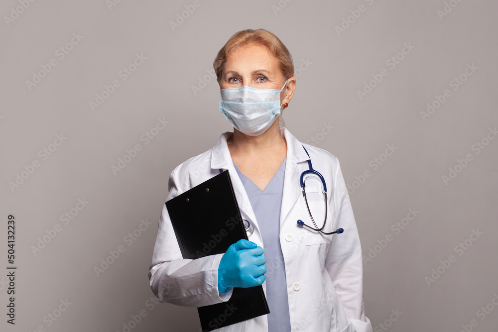 Female scientist or doctor in protective medical mask, stethoscope, blue gloves and white uniform coat portrait Female scientist or doctor in protective medical mask, stethoscope, blue gloves and white uniform coat portrait