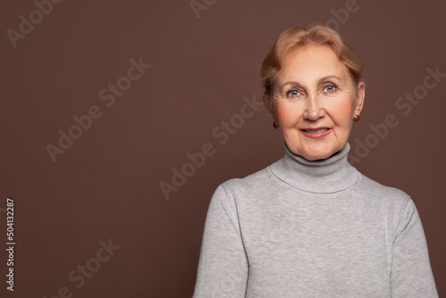 Portrait of a smiling mature woman on brown background