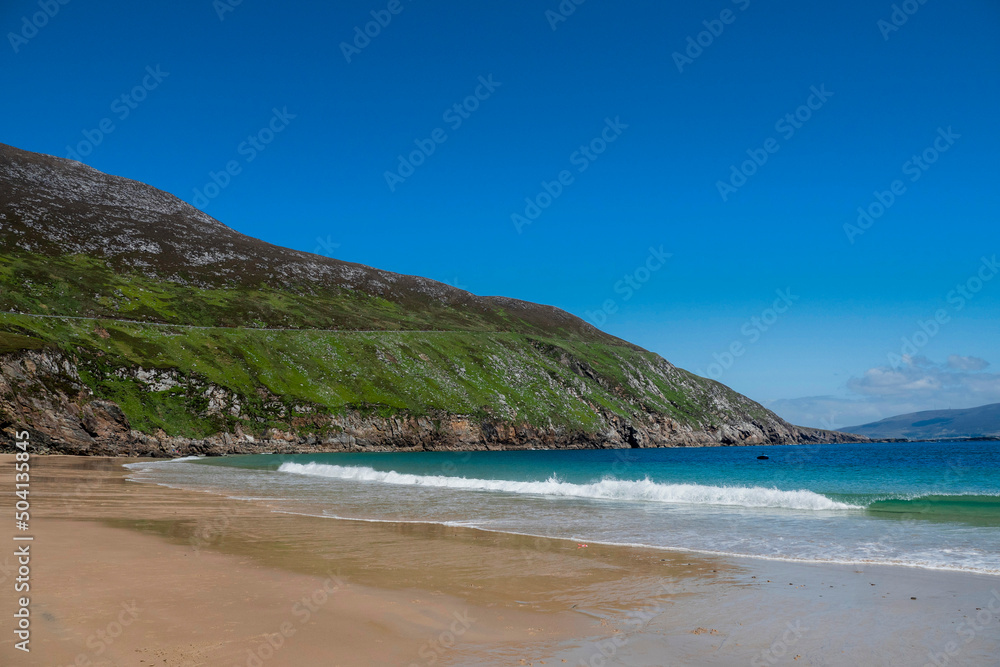 Beautiful sandy Keem beach in Achill island, county Mayo, Ireland. Warm sunny day. Popular travel area with amazing view and nature.