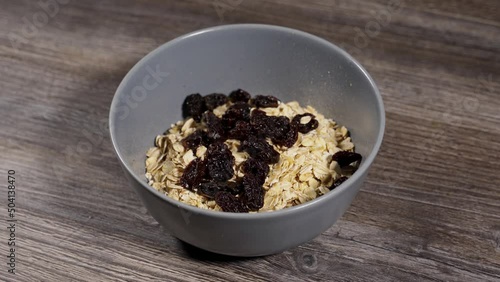 step by step making oatmeal. step 2. oatmeal and suza raisins are poured with boiling water photo