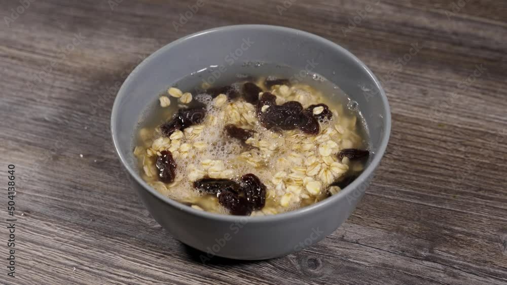 step by step making oatmeal. step 3. oatmeal and suza raisins are poured with boiling water step by step making oatmeal. step 3. oatmeal and suza raisins are poured with boiling water