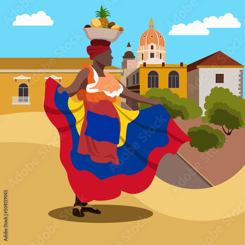 A Colombian woman in a national costume and with a bowl of fruit on her head stands against the backdrop of the famous Colombian architecture. Republic of Colombia