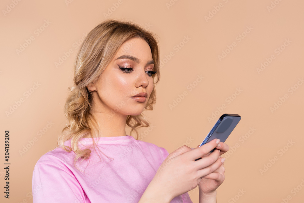 pretty woman with wavy hair chatting on cellphone isolated on beige. pretty woman with wavy hair chatting on cellphone isolated on beige.