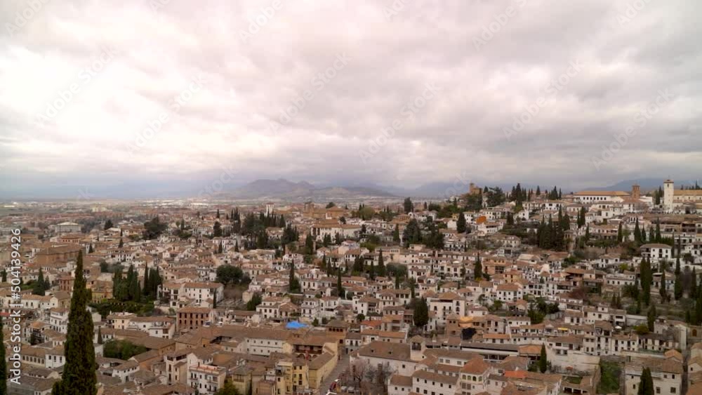 Wide sweeping slow motion pan over cityscape of Granada, Spain