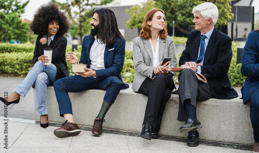 Fototapeta premium Diverse business people doing lunch break outdoor from office building - Focus on center girl face