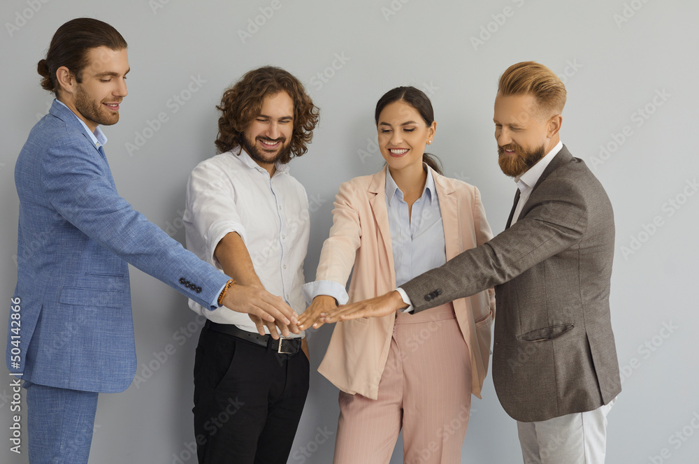 Studio group portrait of happy smiling young business people in suits ...