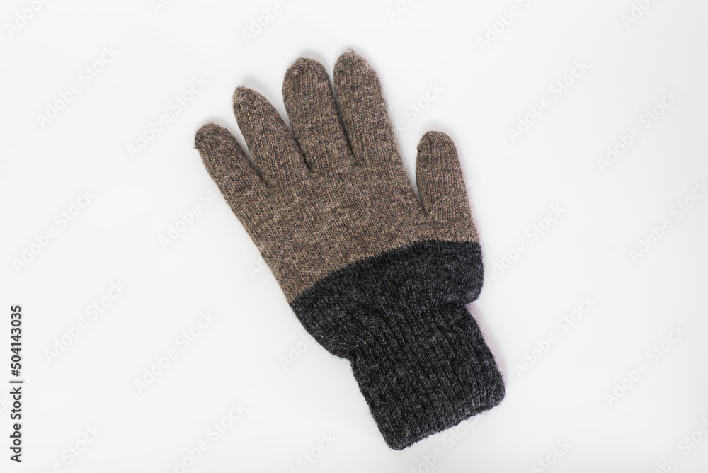 Knitted gray wool glove isolated on a white background. Knitted gray wool glove isolated on a white background.