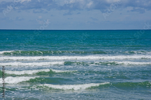 Beautiful white waves in the sea with blue sky background