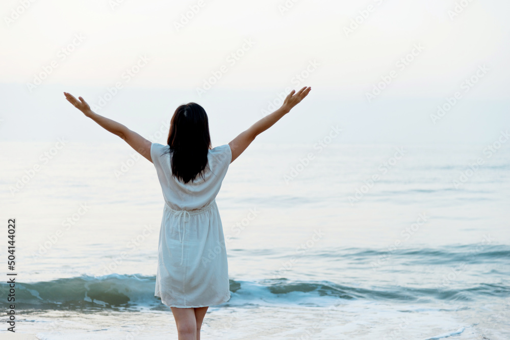 Happy woman standing on the beach with hands up. Happy woman standing on the beach with hands up.