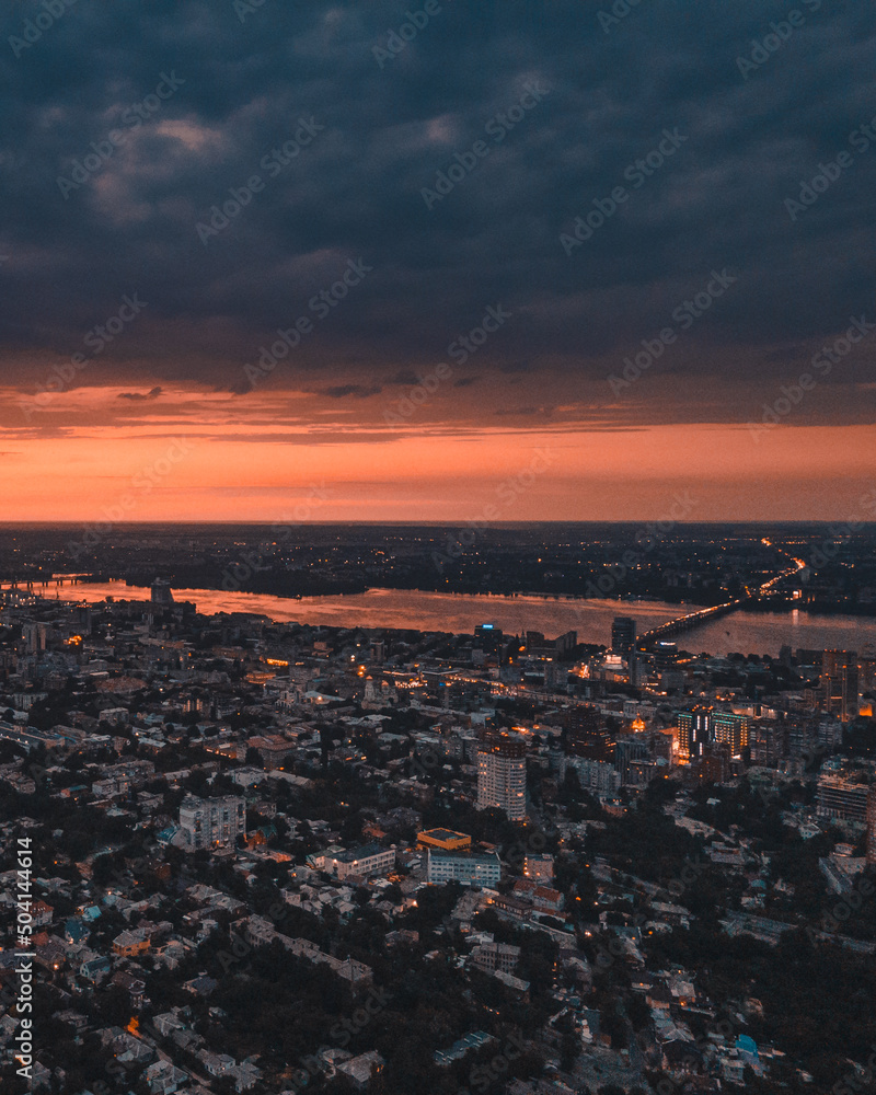 Dnipro, Ukraine. View of the central part of the city of the Dnieper. Top view from a great height. Panoramic view of the city. Dawn or sunset over the city. orange sky