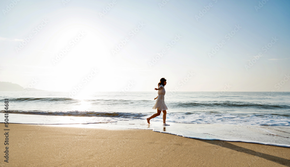 Young woman having fun walking on seaside.