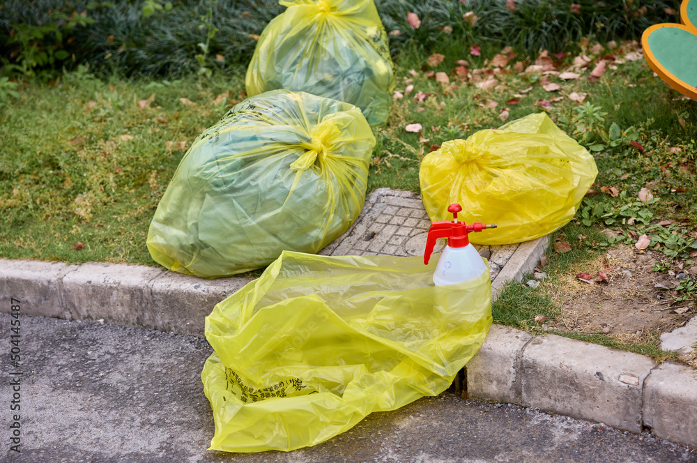 Yellow trash bag of biohazard medical waste on the street