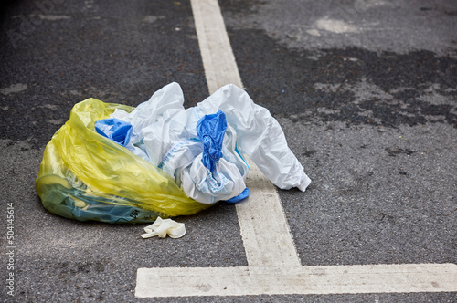 Yellow trash bag of biohazard medical waste on the street, environmental pollution due to the flu pandemic. photo