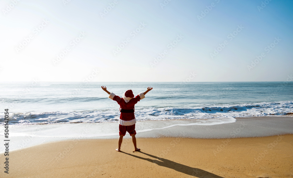 Santa claus standing on beach with arms outstretched. Santa claus standing on beach with arms outstretched.