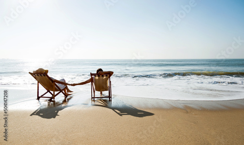 Couple sunbathing on a beach chair.