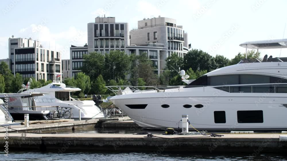 Yacht parking, A marina lot, yacht is moored at the quay. Expensive yachts and boats at the pier. Luxury vacation. Panorama of the city on the beach. View from the pleasure boat. Yacht parking, A marina lot, yacht is moored at the quay. Expensive yachts and boats at the pier. Luxury vacation. Panorama of the city on the beach. View from the pleasure boat.