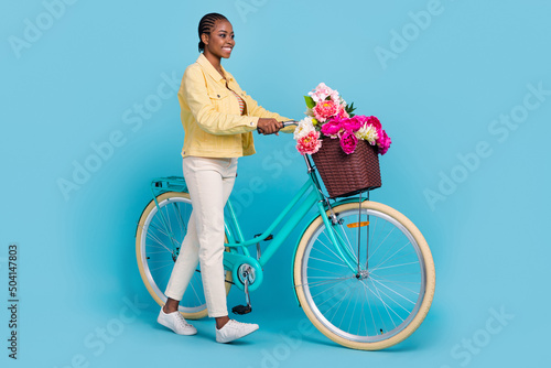 Full length body size view of attractive cheerful girl walking bike strolling isolated over bright blue color background