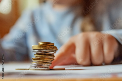 Little girl playing with coins making stacks of money. First lessons in finance. Accumulation. Credit. kid saving money for the future concept