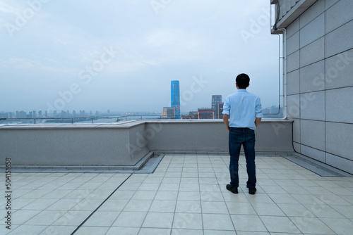 Businessman standing on the rooftop with hands in pocket