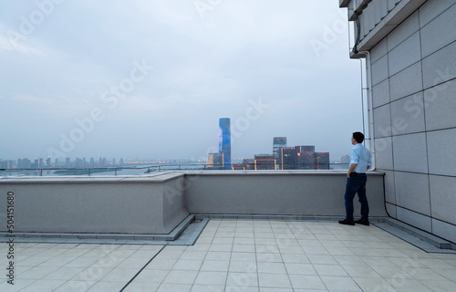 Businessman standing on the rooftop with hands in pocket © xy