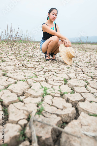 woman walking in dryland with drought ground texture. concept climate changed.