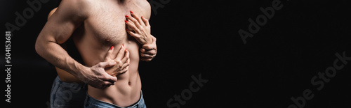 Cropped view of young woman touching sexual boyfriend isolated on black, banner.