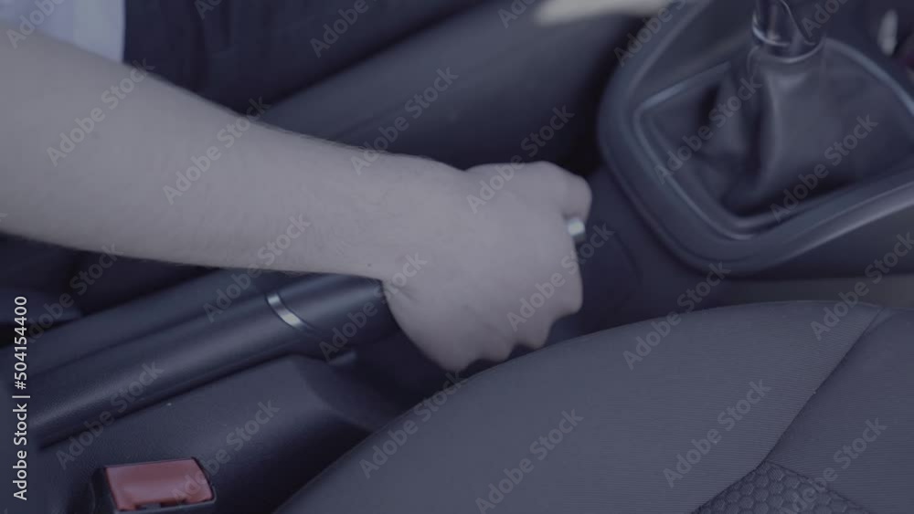 Homme qui serre son frein à main de voiture